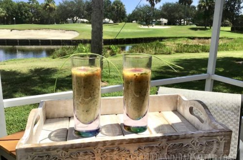 Watercress And Zucchini Soup With Smoked Paprika And Chives In Glasses On Tray Overlooking The Water