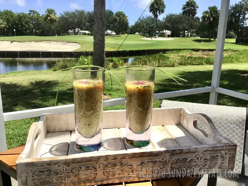 Watercress And Zucchini Soup With Smoked Paprika And Chives In Glasses On Tray Overlooking The Water