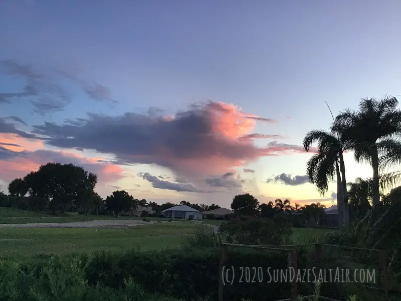 Twilight Descends On Tropical Landscape With Wispy Clouds With Pink Hues