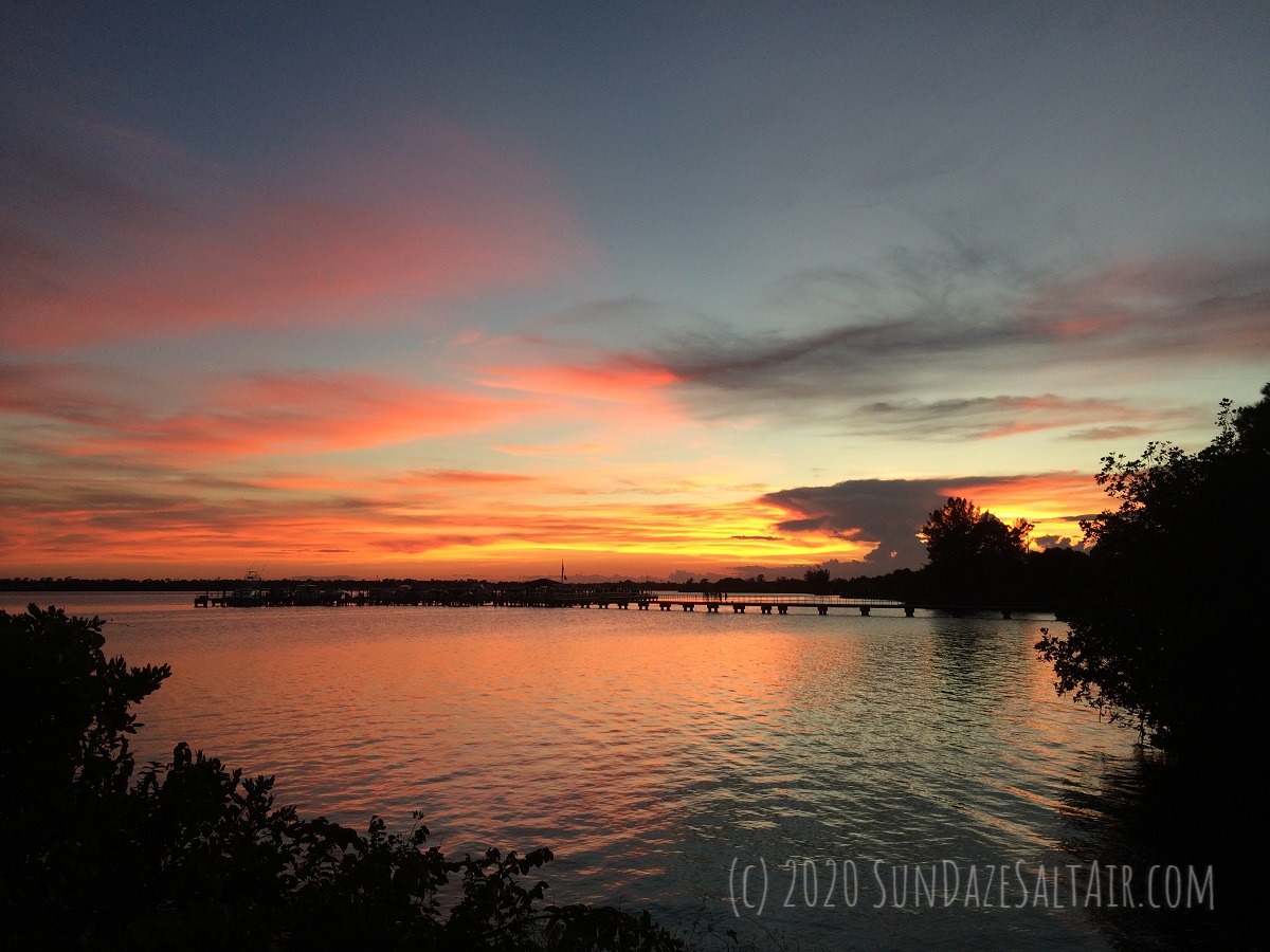 A Fall Twilight Evening At The Dock With Amber Colored Skies Reflected On Tranquil Waters