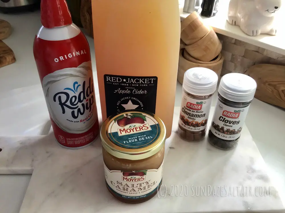 Ingredients for Warm Spiced Salted Caramel Apple Cider Like Starbucks On Marble Cutting Board