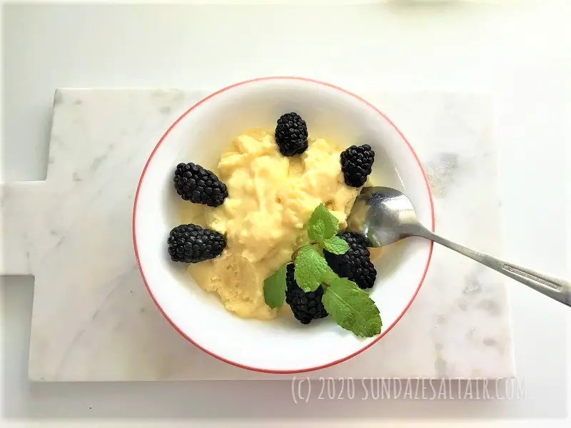 Lemon Pudding Custard Cake Dessert With Mint And Blackberries In A Bowl On A Marble Cutting Board