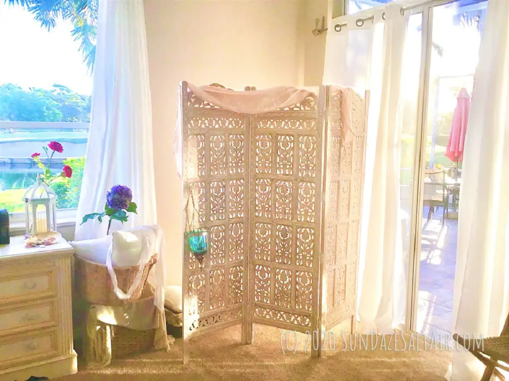 Stunning Eastern-Inspired Room Divider Adds Exotic Intrigue To Any Room As Well As Creating Intimate Spaces With Gently Draped Fabric, An Eastern Moroccan Style Lantern, Flowing Curtains, Baskets For Storage & A Rattan Chair In The Foreground