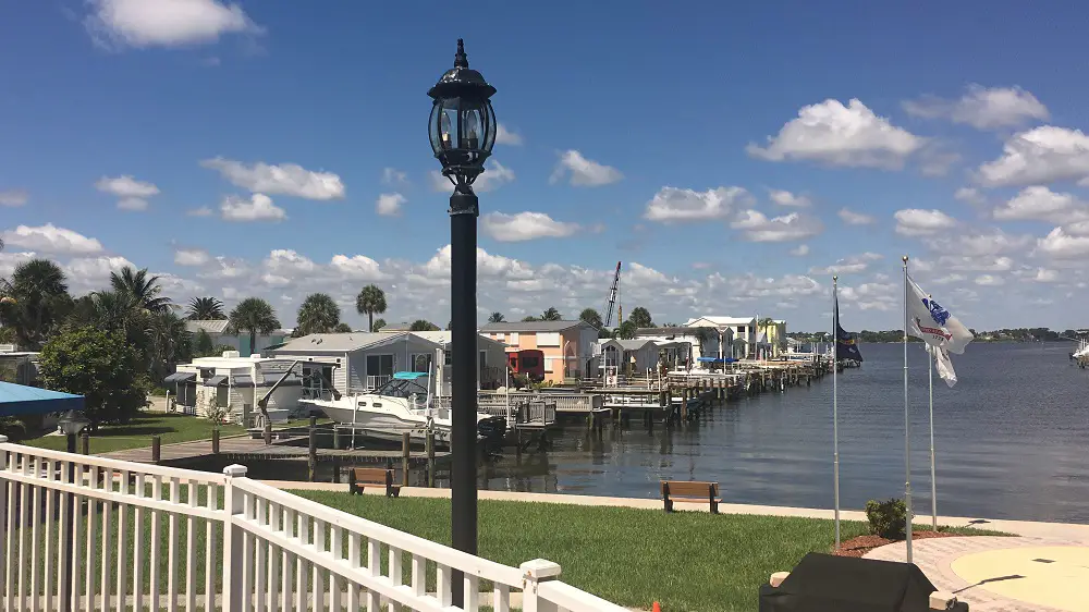 Looking out at quaint beach cottages surrounded by water and palm trees under bright blue skies