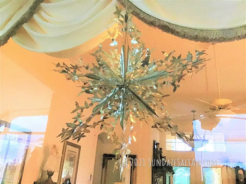 Decorate a room with high ceilings for Christmas with snowflake decor like this silver foil beauty