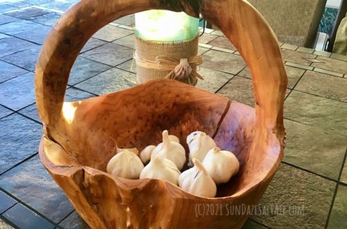 How To Grow Your Own Garlic This Winter For Amazing Flavor & Health Benefits-Garlic bulbs in rustic wood basket on table