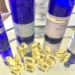 How to Repair the Skin Lipid Barrier Naturally with Evening Primrose Oil capsules on glass & silver tray surrounded by blue bottles